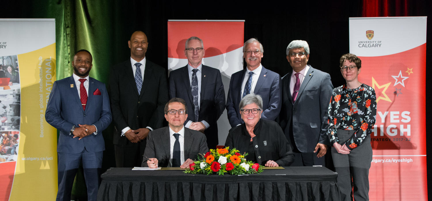 UCalgary’s Dru Marshall and Mitacs' Alejandro Adem sign a collaboration agreement that facilitates international research opportunities for students. Standing, from left: Angelo Nwigwe, Oba Harding, Ed McCauley, Andre Buret, Janaka Ruwanpura and Heather Clitheroe. Photo by Adrian Shellard, for University of Calgary International