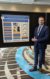 A man stands in front of a presentation board