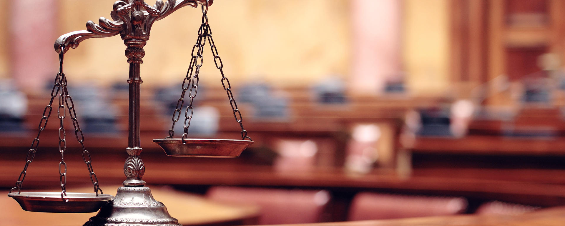 The scales of justice pictured in a court surrounding 