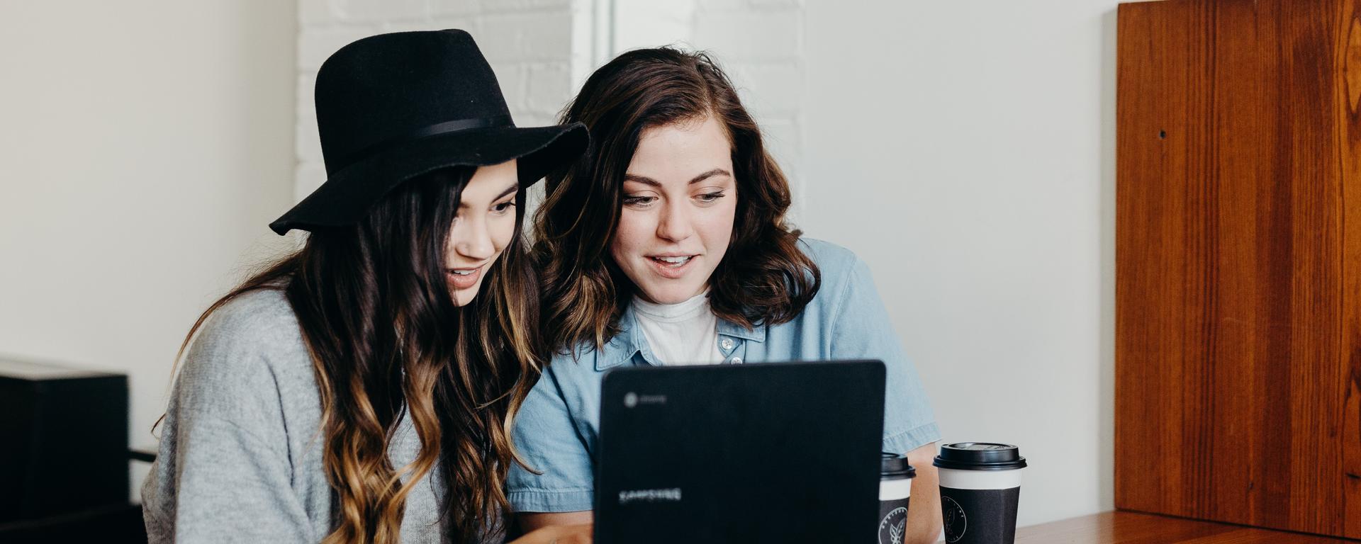 Two young women looking at a laptop together
