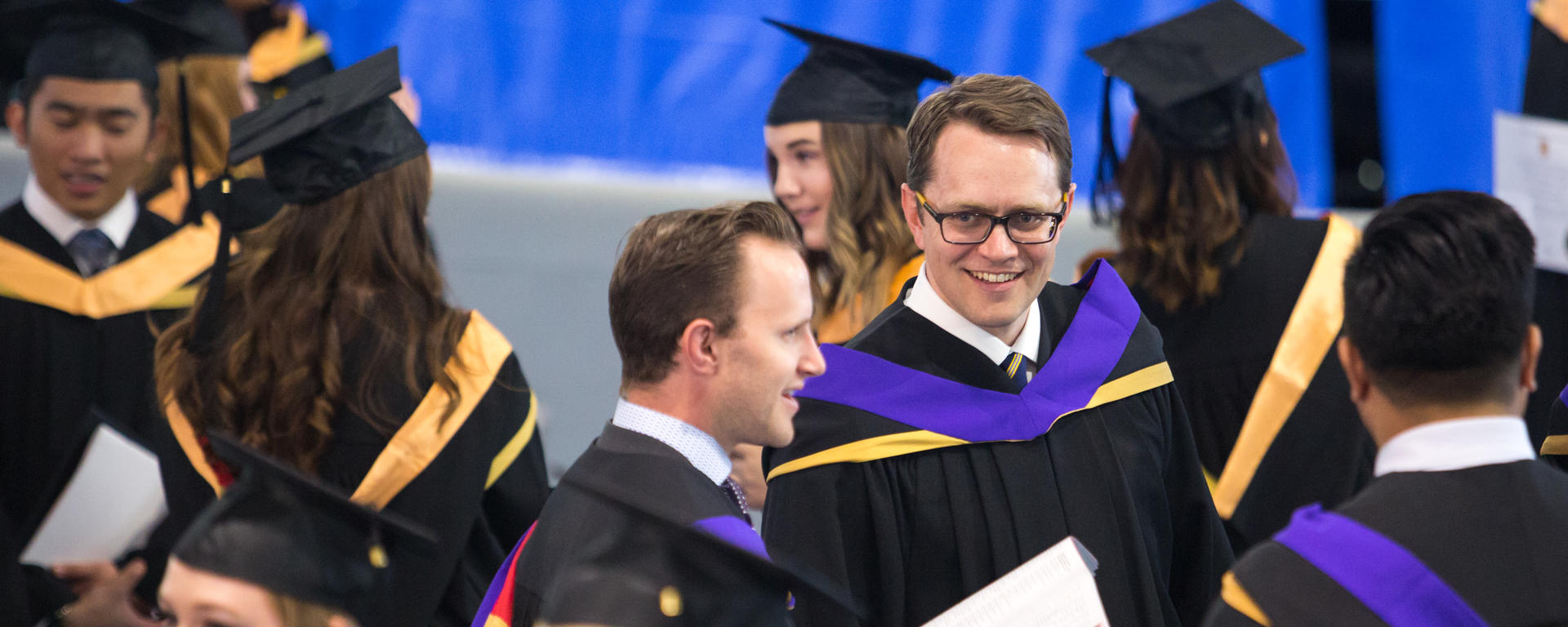 Law school graduates chat in the Olympic Oval prior to convocation ceremonies