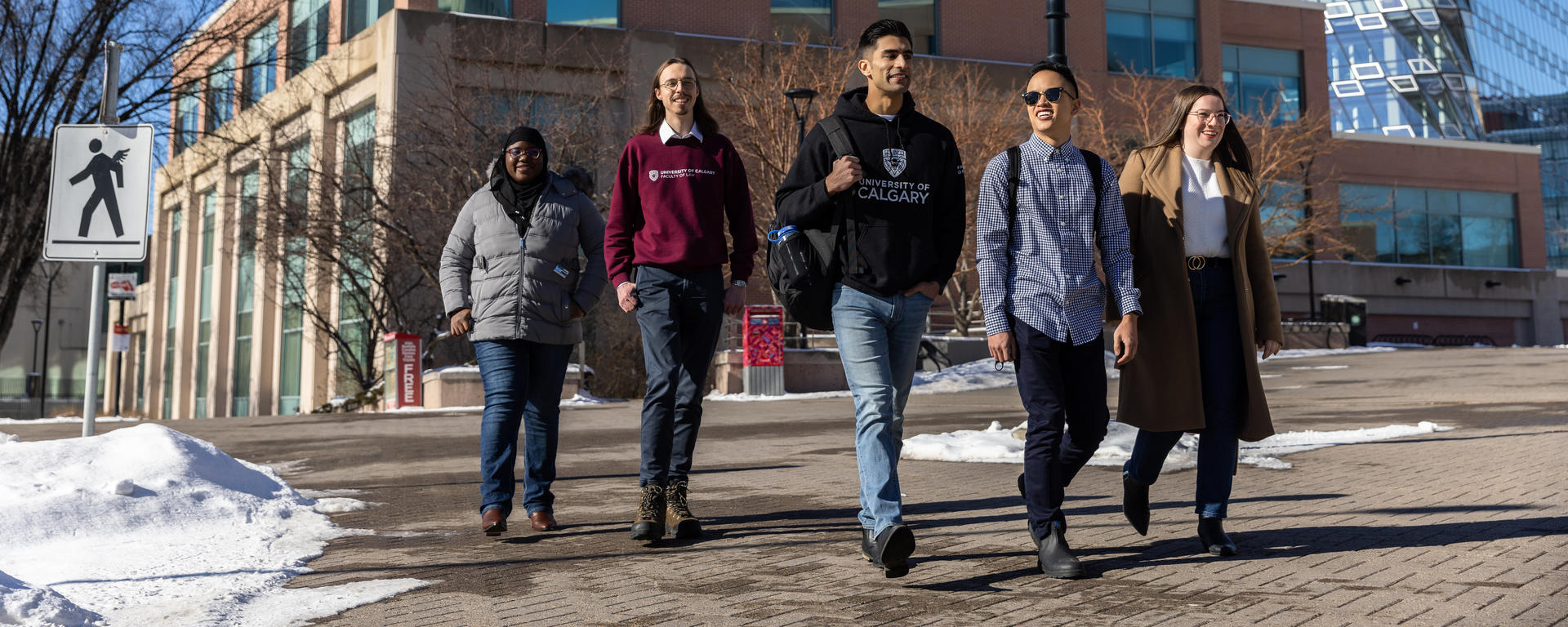 Five students walk in front of Murray Fraser Hall.