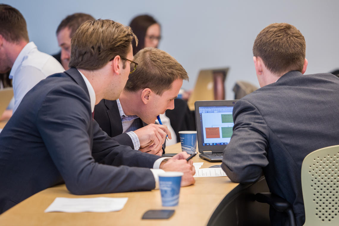 Three students looking at laptop