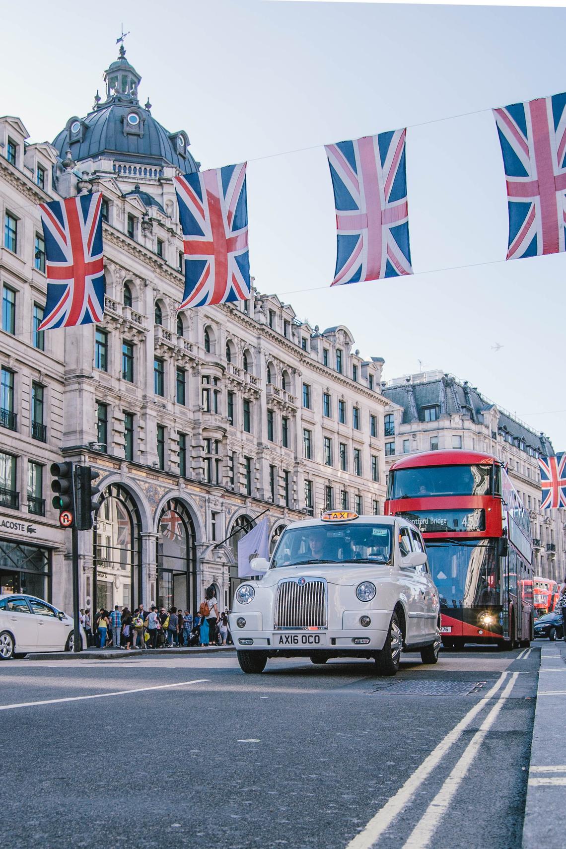 Photo of London street with building, taxi, and bus in the background