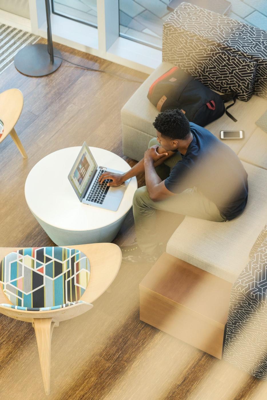 Man sitting on a couch and using a laptop