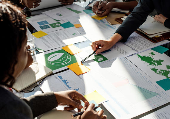 A group of people work together on papers and spreadsheet.