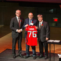 Left to right: President Ed McCauley, Professor Emeritus Al Lucas, UCalgary Law Dean Ian Holloway. Al holds a Calgary Stampeders football jersey with the number 76 on the back.