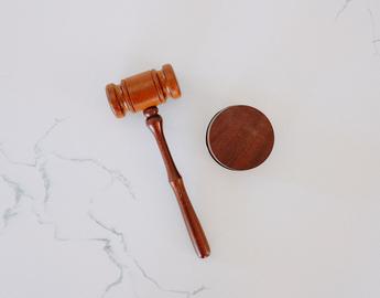 Gavel and block laying down on white surface